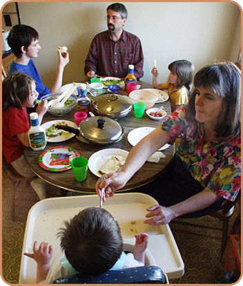 adults and children at table eating